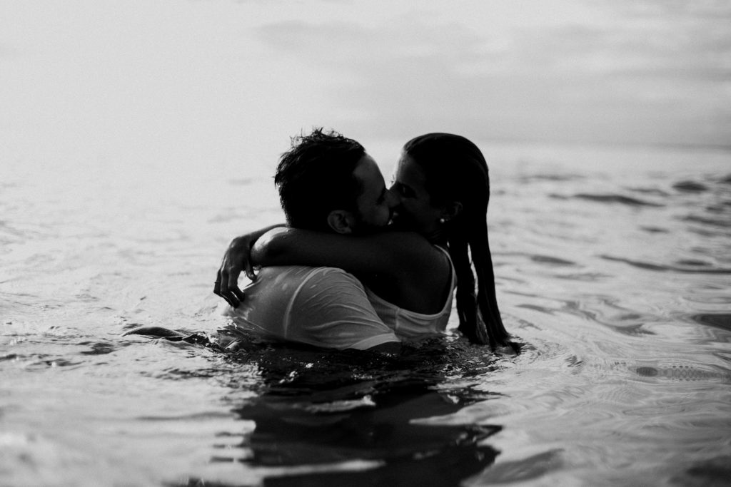 para kochanków, kobieta i mężczyzna całują się w morzu
