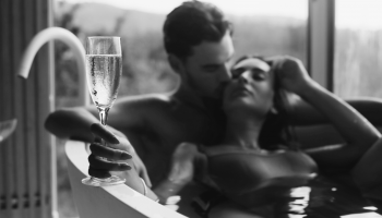 kobieta i mężczyzna w wannie w zmysłowej pozie z lampką szampana